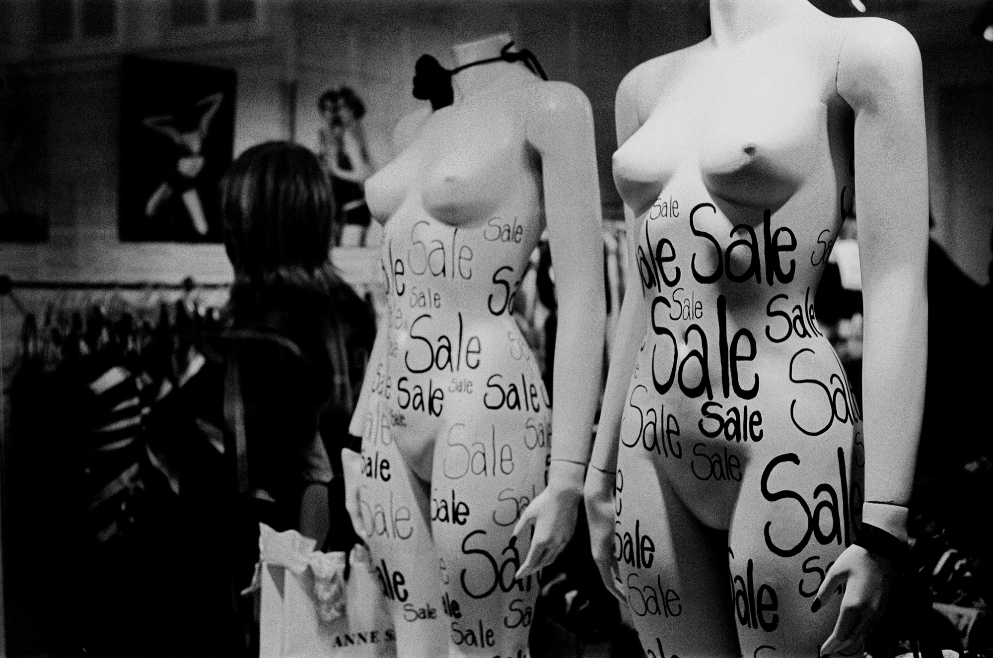 Mannequin covered in Sale text in a shop window