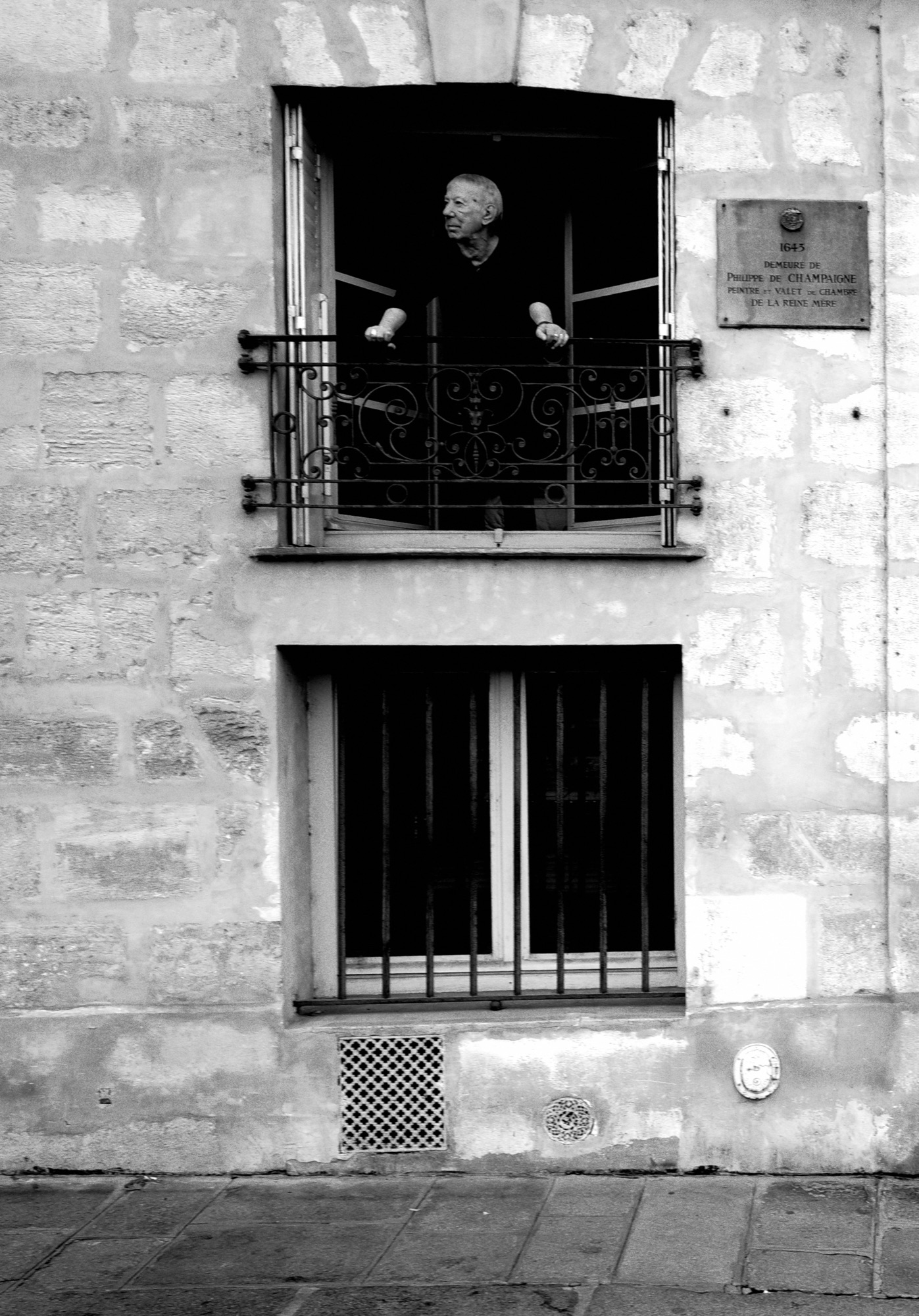Man standing on a balcony with ornate iron railings