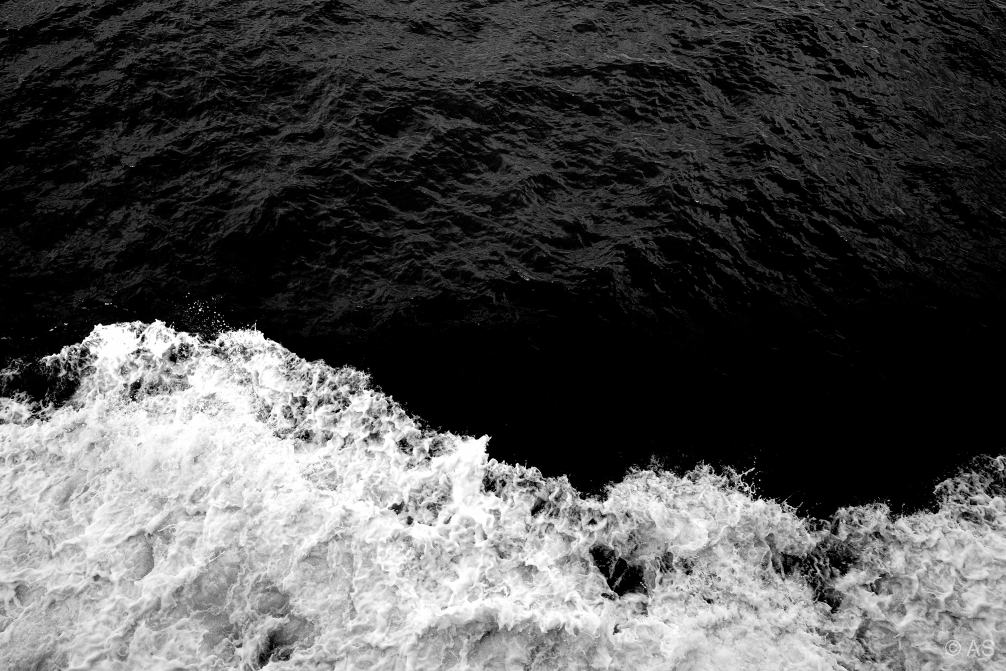 Dark water meeting white foam and waves